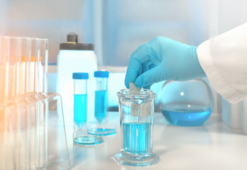 Scientific background with glass slide in gloved hand