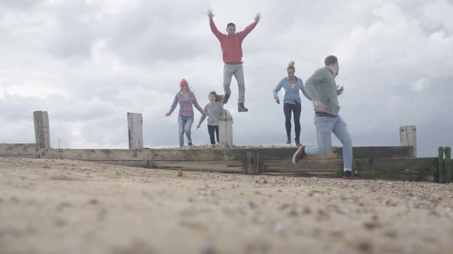  Happy friends hanging out together, running & having fun at the beach