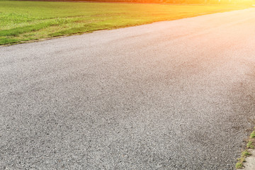 Asphalt road and green grass background
