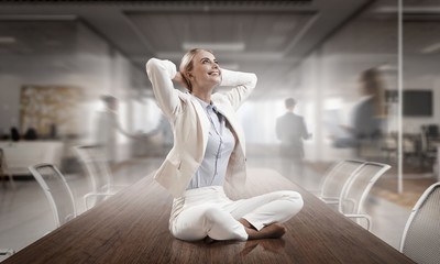 Business lady meditating at work. Mixed media