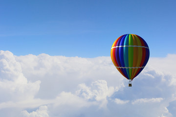 Aerostat floating in day sky. Mixed media