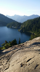 Standing on a rocky ledge overlooking a secluded lake in the mountains