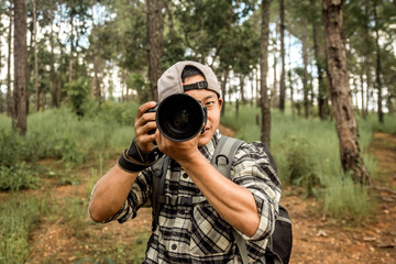 Photographer at happy sunny day outdoor photo session in forest