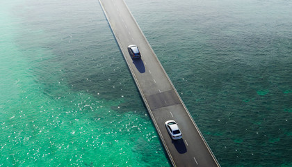 Fototapeta na wymiar Two car drive pass on flyover bridge at sea , Aerial view .
