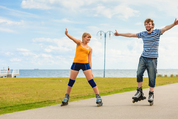 Young couple on roller skates riding outdoors