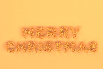 Merry Christmas words from orange balls on orange background