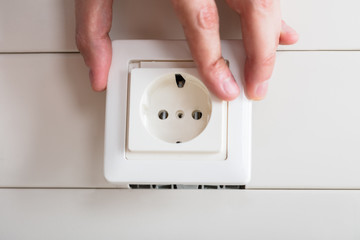 Person's Hand Repairing Electrical Socket