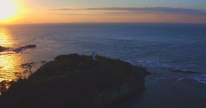 灯台に日の出が差し込む恵比須島（伊豆下田）