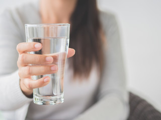 Young woman holding drinking water glass in her hand. Health care concept.