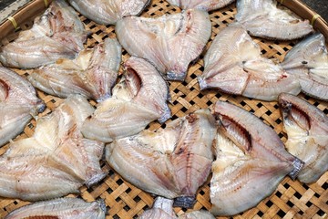 dry salty nile tilapia fish on bamboo floor