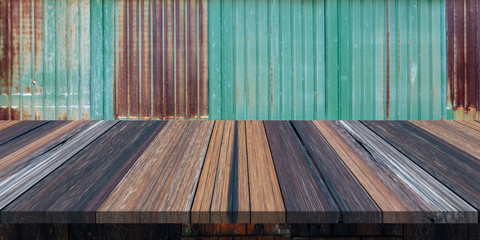 Empty wooden table or plank with old rusty zinc wall on background for product display.