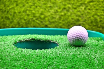 Golf is on green next to hole