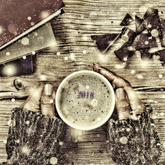 New Year Christmas. A cup of coffee or a cup of tea in his hand, and women crushed dark chocolate,...