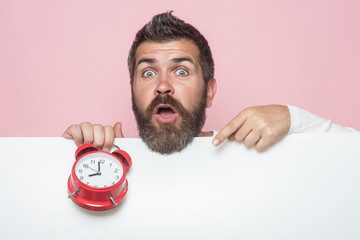 Man with long beard hold alarm clock.