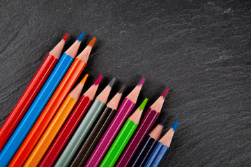 Colored pencils on a black stone slate