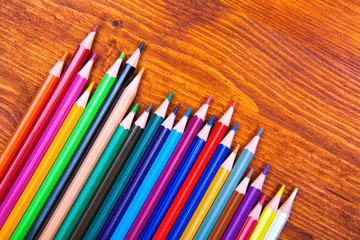 Fototapeta premium Color pencils on wooden table background. Close up