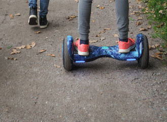 Gyroscooter rides on the road. The legs of a teenager on Gyroscooter goes on the road. 
