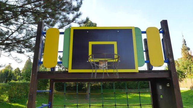 Ball going through basket hoop in school basketball court. Basketball falls through the chain net.
