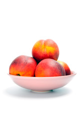 Ripe peaches in bowl isolated on white