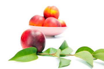 fresh peach fruits with green leaves isolated on white background