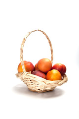 Basket full of fresh peaches isolated on white background