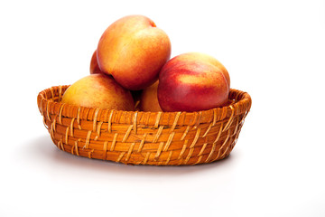 Fresh fruit nectarines in the basket, on white background