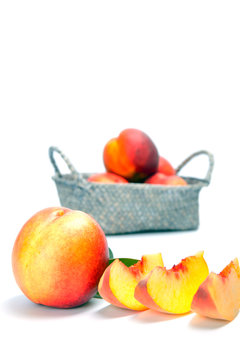 Ripe fresh nectarines in the wicker basket isolated on a white background