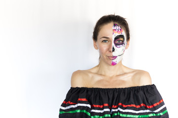 Sugar Skull Halloween Makeup.  Dia de los Muertos. Brunette girl with Mexican style Halloween face painting. Red rose, flower hair decor