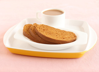Rusk, a popular, crunchy and crispy biscuit, and tea, on a plate.