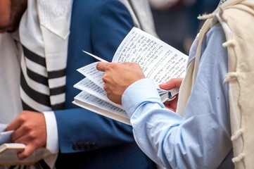 Prayer. The Jewish Hasid reads a religious book. Close-up of a book and hands.