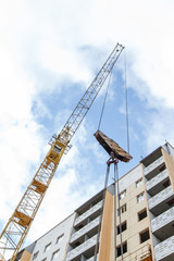 Fototapeta premium tower crane lifts cargo