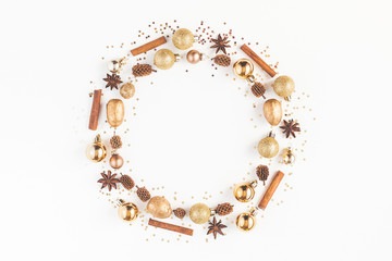 Christmas composition. Christmas wreath, pine cones, golden decorations, cinnamon stick, anise stars on white background. Flat lay, top view, copy space