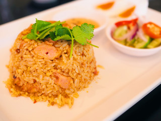 Close up Thai local traditional stir fried rice with Satay Pork, decorated with coriander parsley leaf, on white ceramic plate