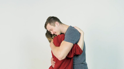 Young man hugging girlfriend. Young couple embraces after a long separation, on a white background