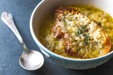 French onion soup with cheese and croutons and a spoon