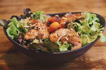 Chicken salad on wood background in restaurant lgiht