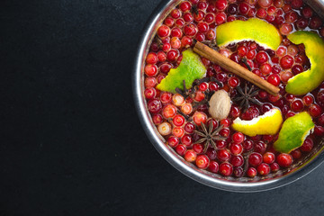 Cranberry, cinnamon and peel in a saute pan on a black stone