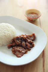 fried pork with garlic and rice on wood background , Thai food