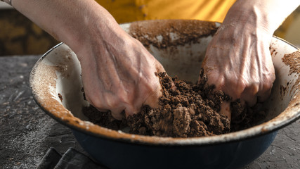 Mixing the dough with your hands in a large bowl close-up