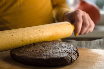 Dough made of flour and cocoa roll on a board side view