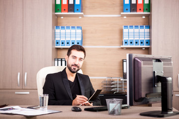 Happy Businessman working in his office. Businessperson in professional environment