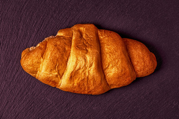 Fresh croissant on dark background.