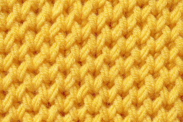 Texture of knitted fabric. Background of orange flowers with knitted needle patterns.