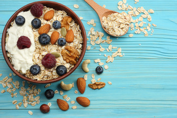 healthy breakfast. oatmeal, honey, blueberries, raspberries and nuts on blue wooden table. Top view with copy space