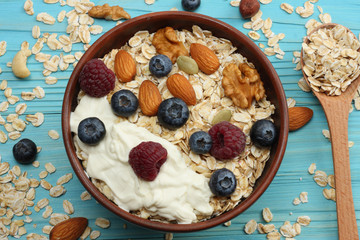 healthy breakfast. oatmeal, honey, blueberries, raspberries and nuts on blue wooden table. Top view with copy space