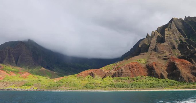 Na Pali coast from moving boat beautiful ocean landscape. Na Pali coast with mountain cliff steep into water. Kauai is the oldest Hawaiian Island. Garden Isle. Economy is tourism based.