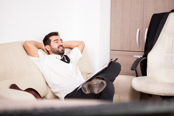 Fototapeta premium Businessman working in the office on the couch putting long hours of work. Businessperson in professional environment