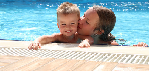 Happy Family Relaxing In Swimming Pool