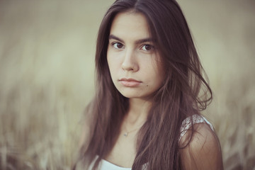 Naklejka premium Sad lonely young girl in a field bored with depression