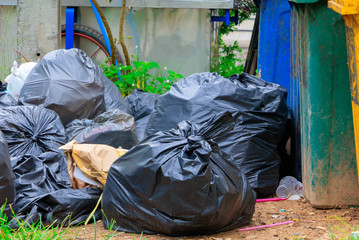 Pile black garbage roadside and Rain drops on the bag  in the city with copy space add text